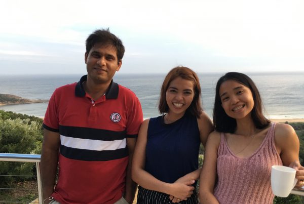 3 members who are apart of Nursing Careers Australia, standing next to each other with land and a sea view behind them